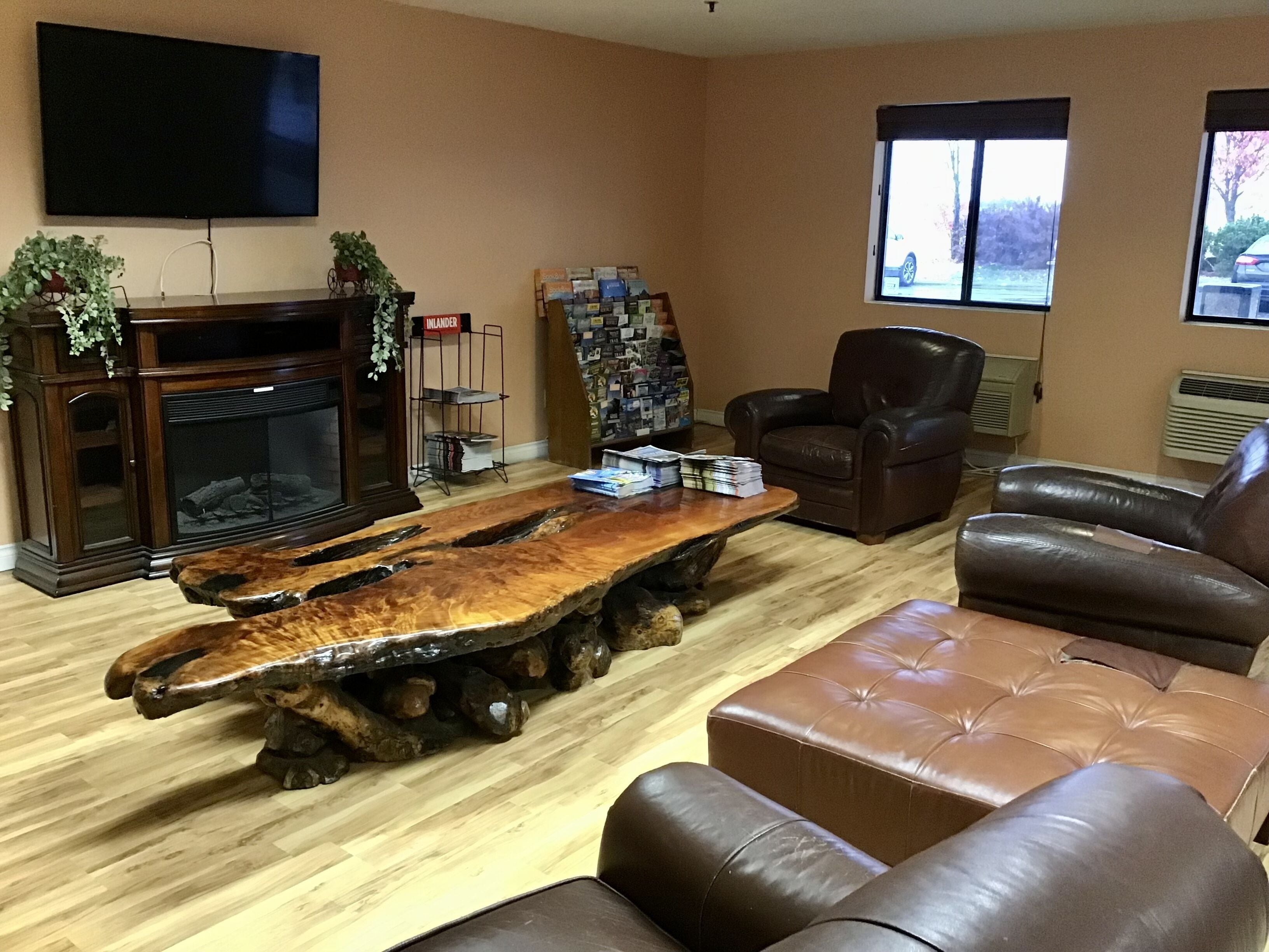 A living room with a wooden coffee table, leather sofa, and a fireplace.