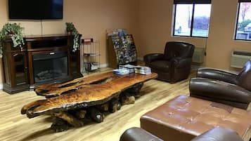 A living room with a wooden coffee table, leather sofa, and a fireplace.