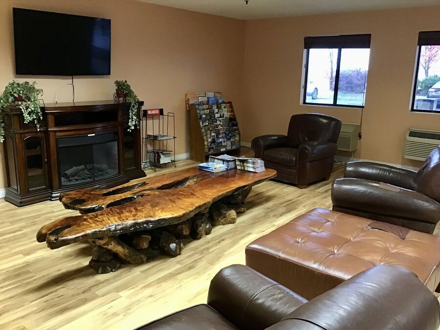 A living room with a wooden coffee table, leather sofa, and a fireplace.