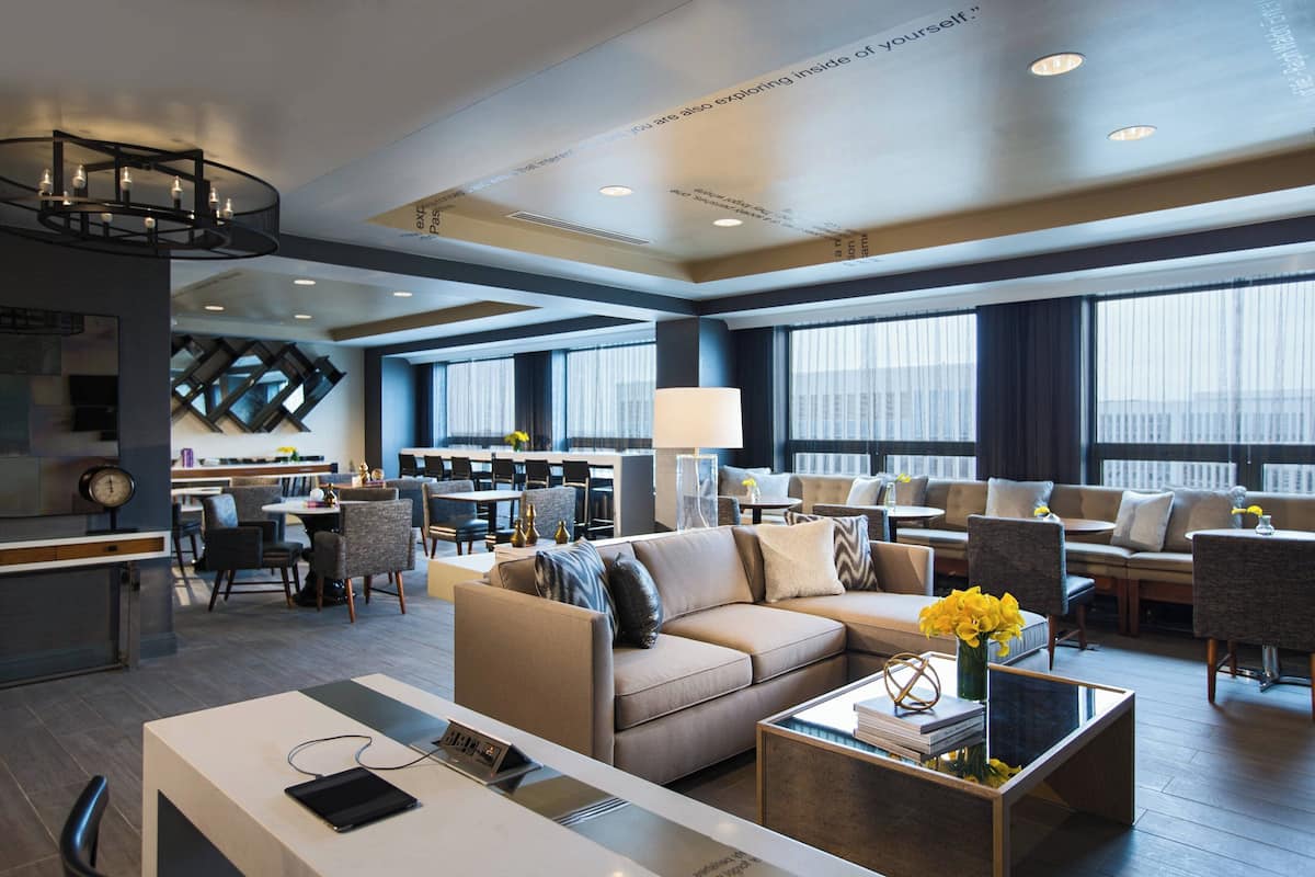A modern hotel lobby with a sofa, coffee table, and a reception desk.