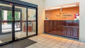 A hotel entrance with a reception desk, emergency exit doors, and a tiled floor. - Best Western Carowinds (Fort Mill)