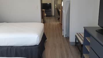 Une chambre d’hôtel avec deux lits, un bureau, une télévision et une armoire.