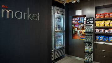 A refrigerated display case with various beverages and snacks, a sign reading "LIFE WTR", and a shelf stocked with bags of chips.