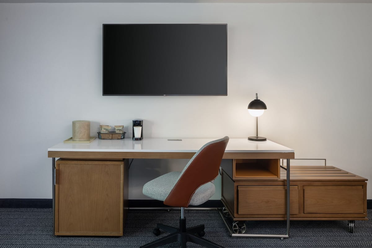 Luxe beddengoed, donzen dekbedden, een bureau, een laptopwerkplek