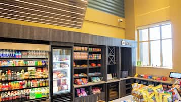 Interior de un supermercado con secciones refrigeradas, estantes llenos de productos y una zona de cajas.