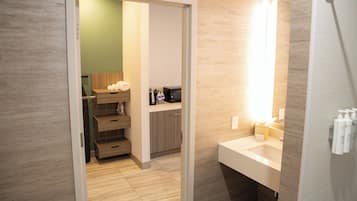 A modern bathroom with a wooden vanity, a mirror, and a shower area.