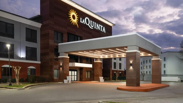 A hotel with a prominent 'La Quinta' sign, a covered entrance, and a brick facade. - La Quinta Inn & Suites by Wyndham Bessemer (Bessemer)