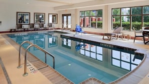 An indoor swimming pool with clear water, a lifeguard chair, and a seating area with chairs and tables. - La Quinta Inn & Suites by Wyndham Bessemer (Bessemer)