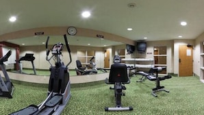 Un gimnasio con cintas de correr, elípticas y estaciones de pesas.