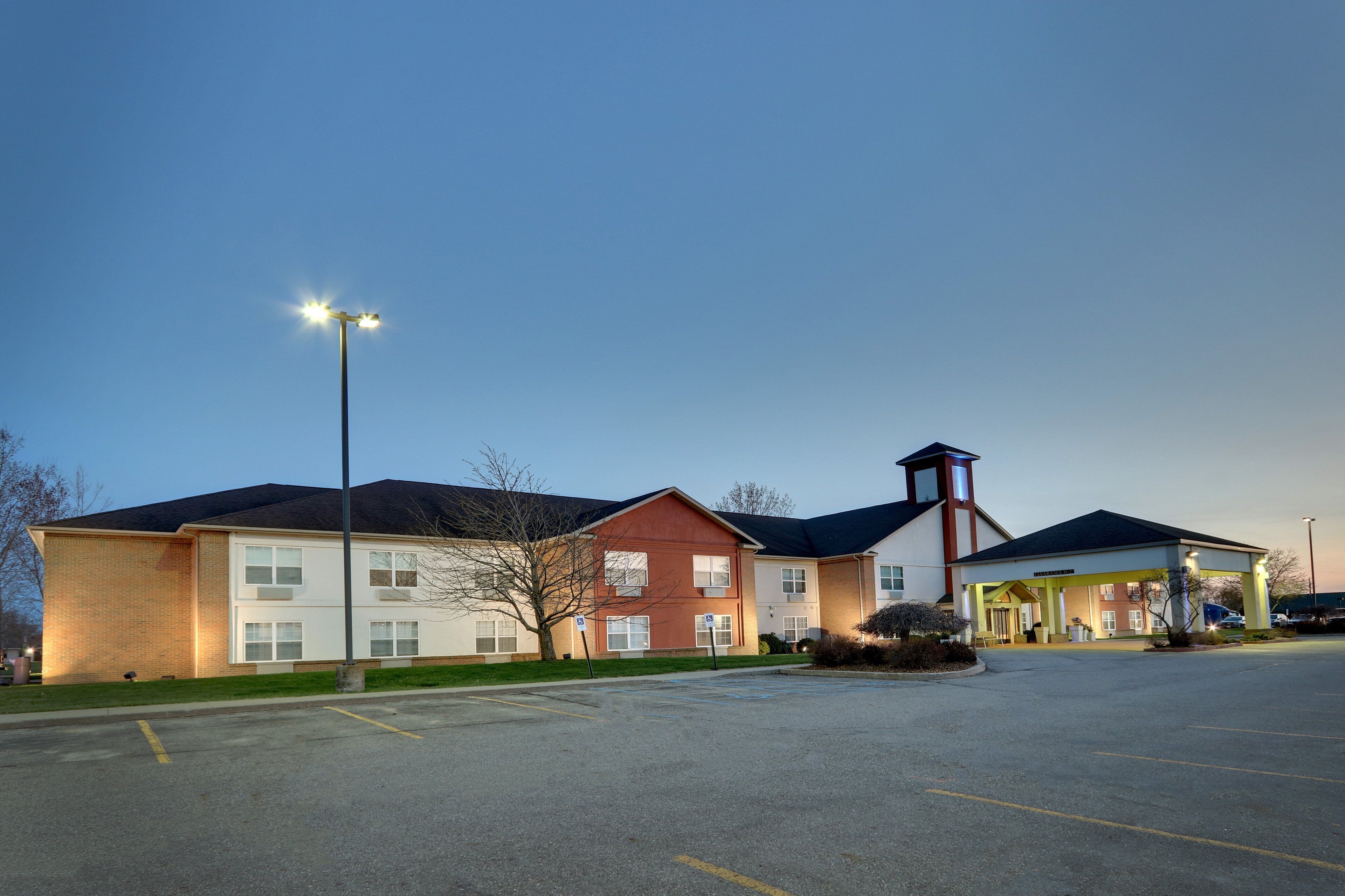 A multi-story building with a parking lot in front.