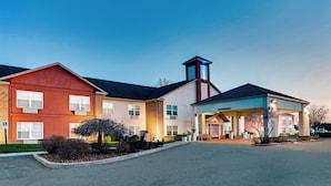 A hotel with a red and white facade, a covered entrance, and a parking lot. - Holiday Inn Express Hotel & Suites Bad Axe by IHG (Bad Axe)