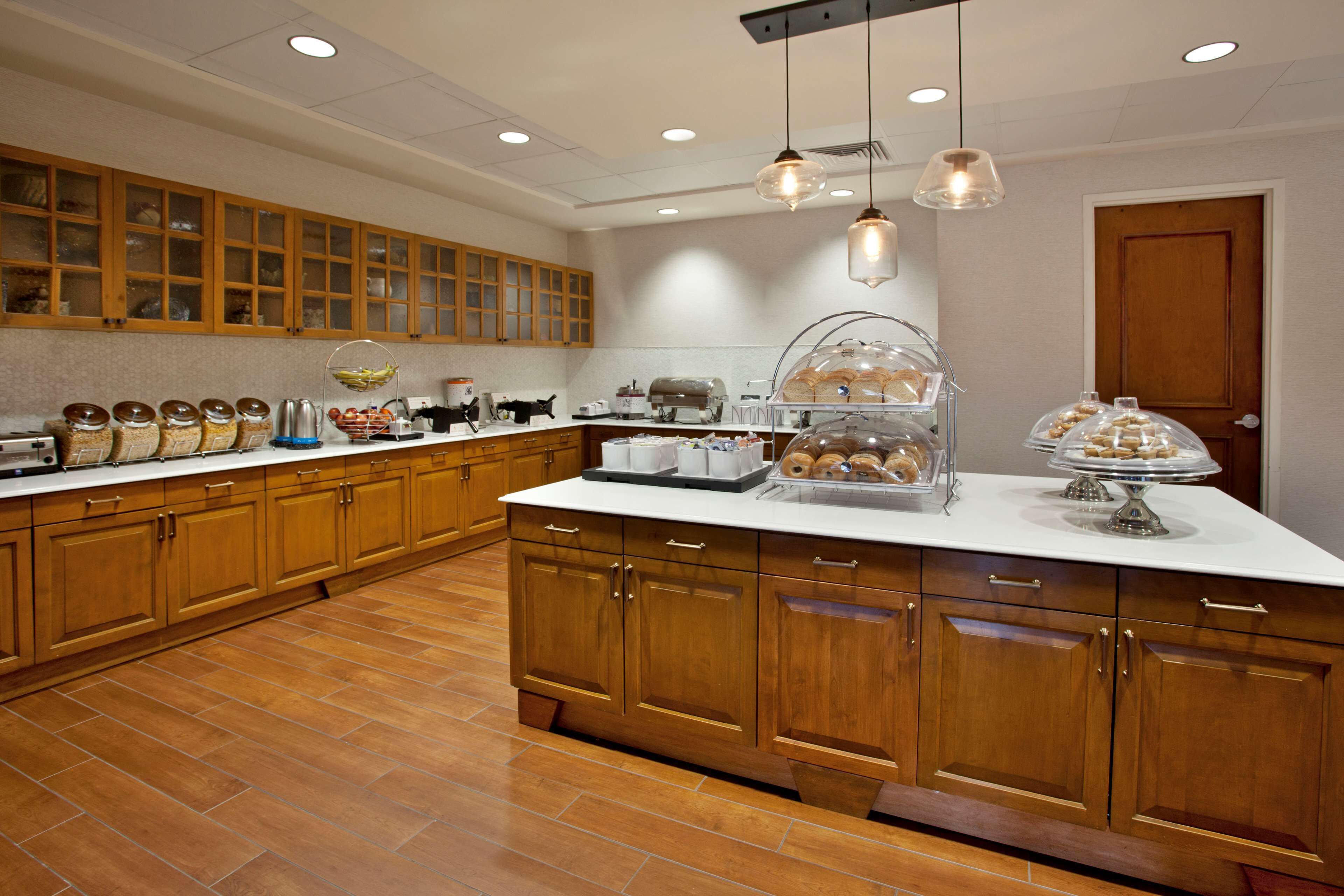 A spacious kitchen with wooden cabinets, a large island, and various kitchen appliances.