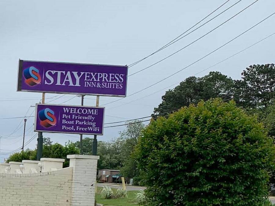 A sign for StayExpress Inn & Suites, indicating pet-friendly parking, a pool, and free WiFi.