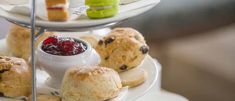 A multi-tiered tray of assorted sandwiches, scones, and desserts.