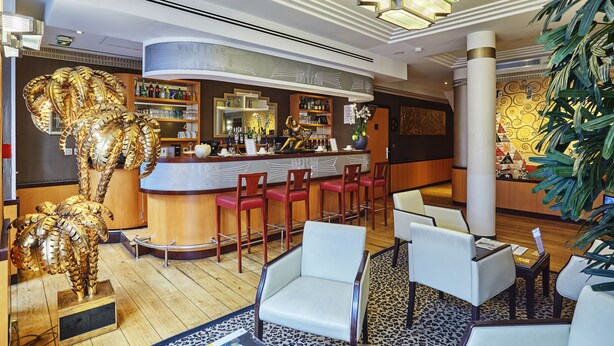 A bar area with a counter, bar stools, and a decorative golden elephant sculpture.