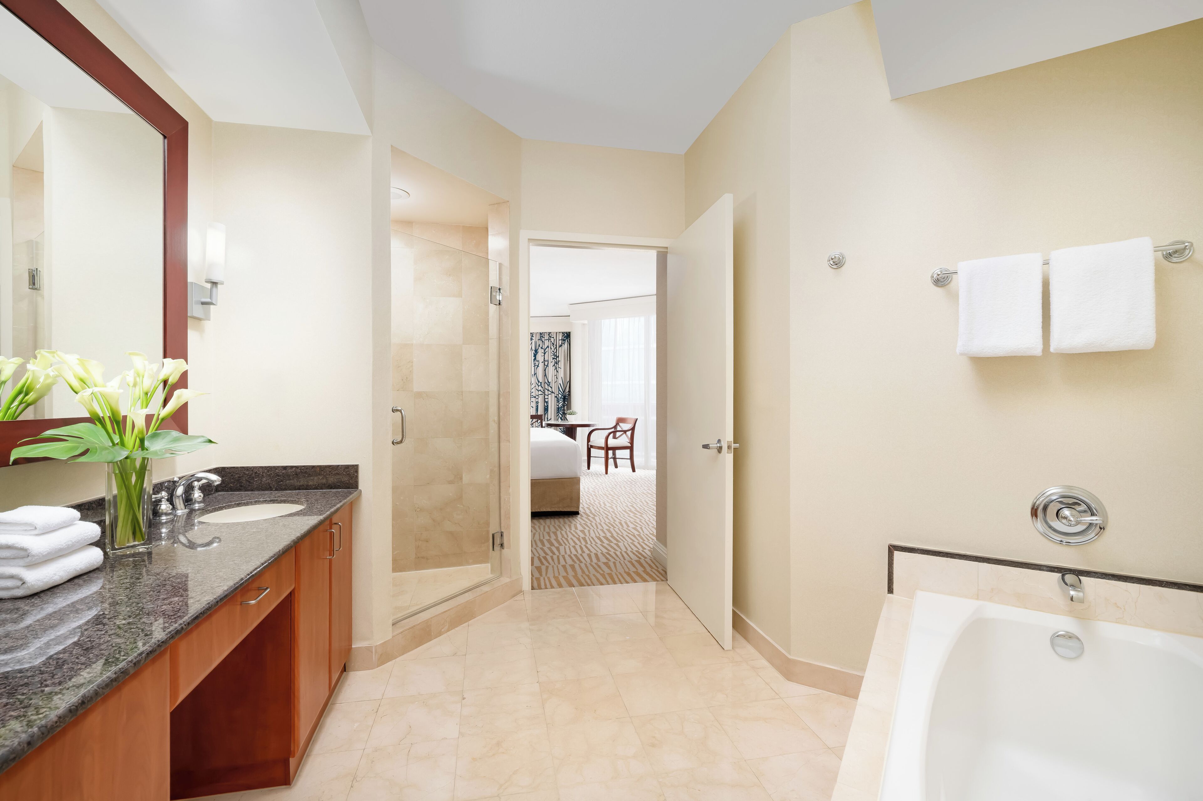 A modern bathroom with a large mirror, a bathtub, and a shower area.