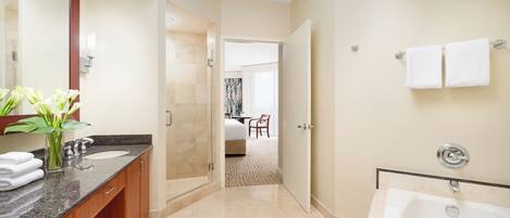 A modern bathroom with a large mirror, a bathtub, and a shower area.