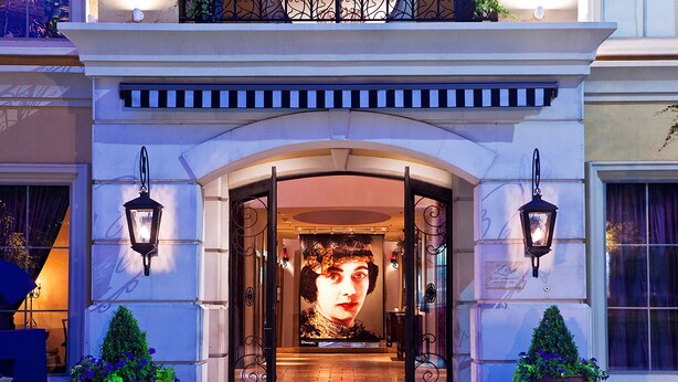 A grand entrance with an arched doorway, two ornate lanterns, and potted plants on either side. - Hotel ZaZa Dallas (Dallas)