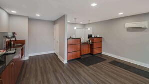 A modern kitchen with wooden cabinets, a countertop, and a built-in stove. - Americas Best Value Inn Farmington (Farmington)