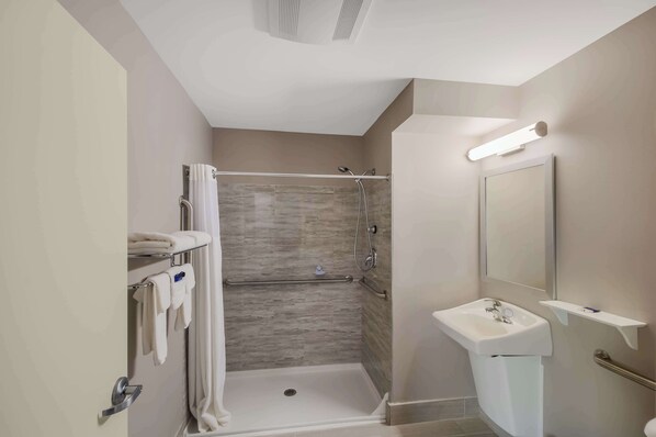 A modern bathroom with a walk-in shower, a sink, and a mirror.