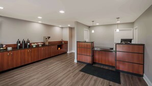 A modern kitchen with wooden cabinets, a built-in oven, and a coffee station. - Americas Best Value Inn Farmington (Farmington)