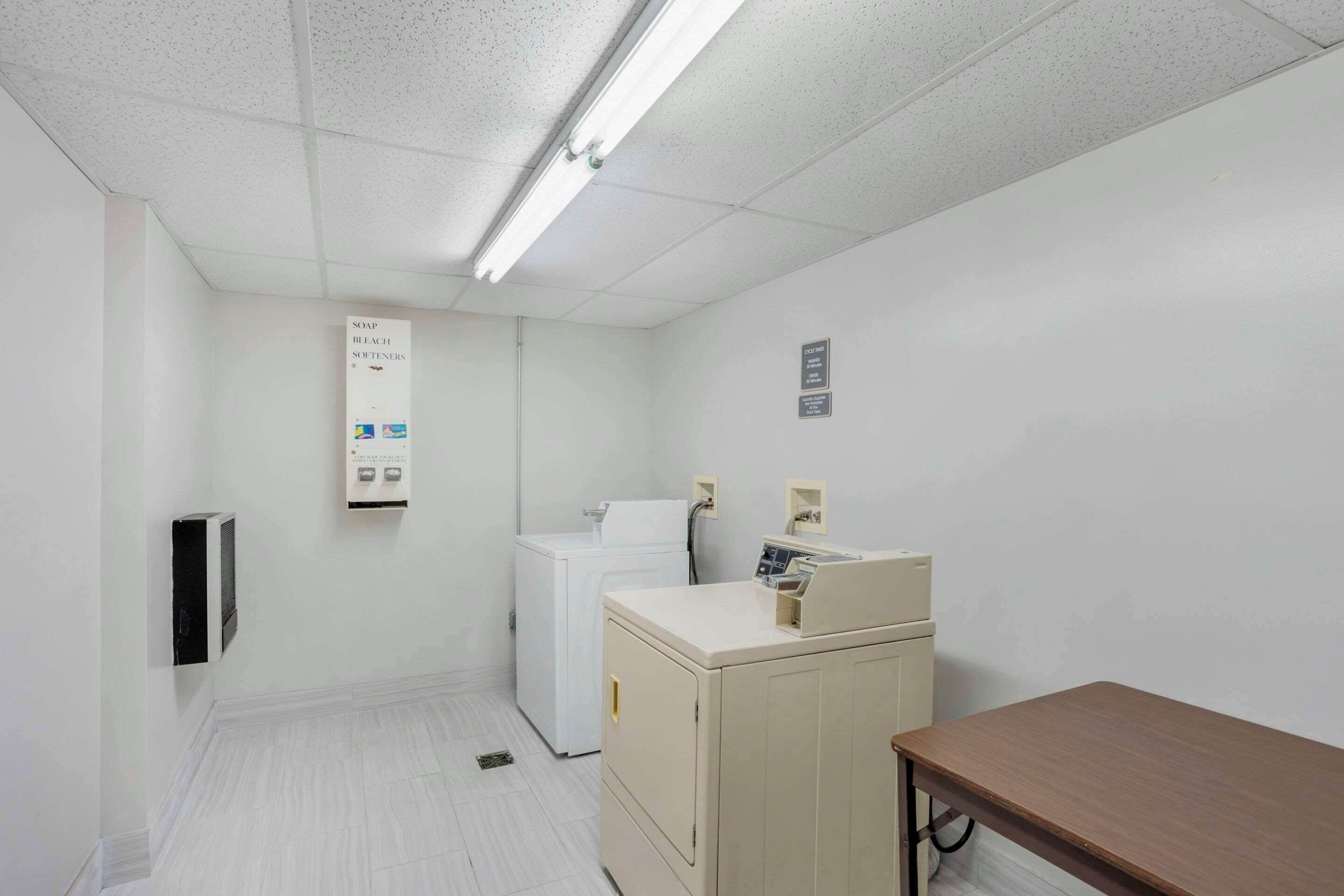 A laundry room with a washing machine, dryer, and a cabinet with a control panel.