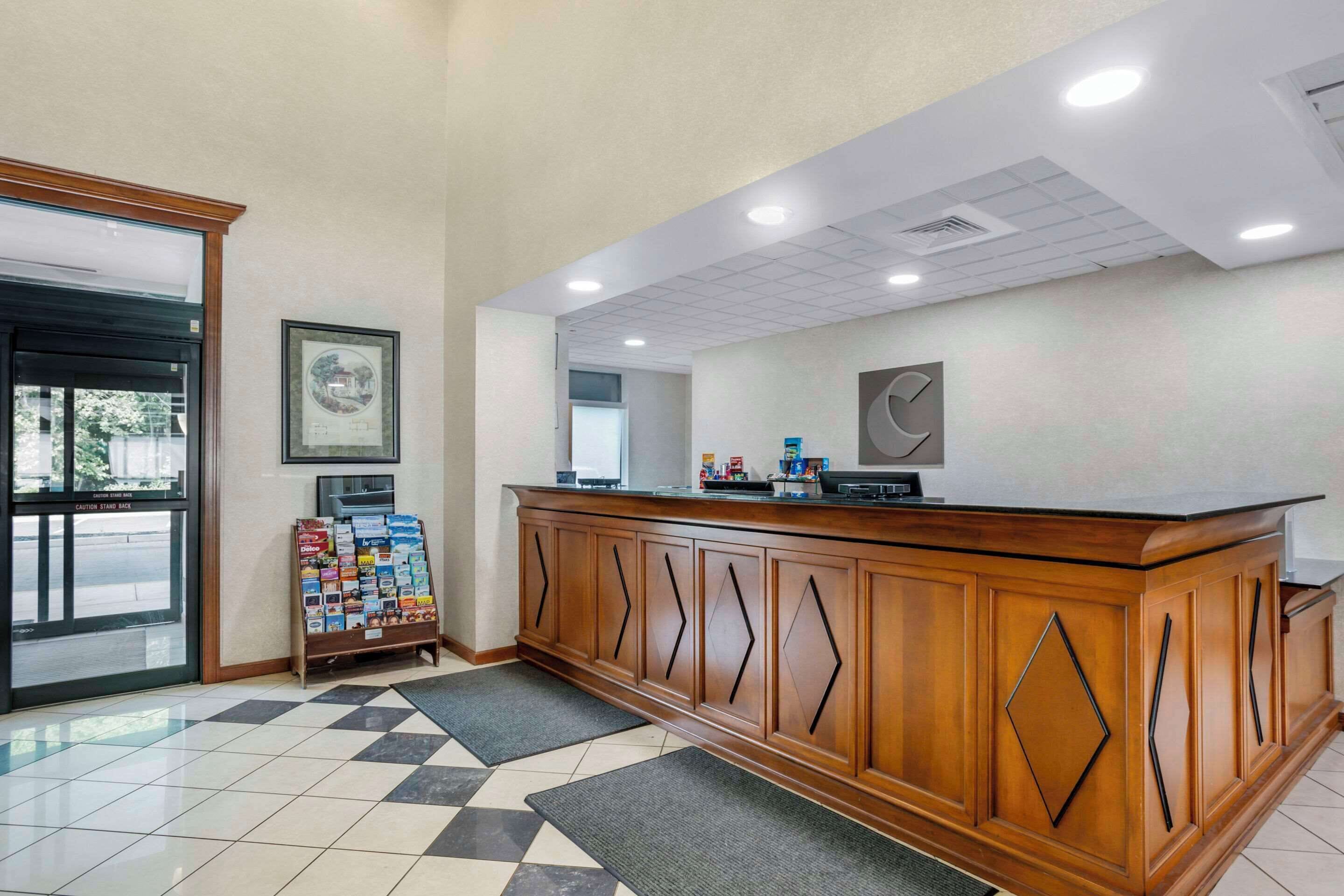 A reception area with a wooden counter, a framed picture on the wall, and a check-in kiosk.