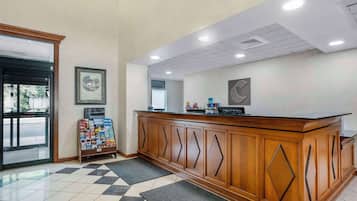 A reception area with a wooden counter, a framed picture on the wall, and a check-in kiosk.