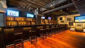 A bar area with multiple TVs, a bar counter, and seating.