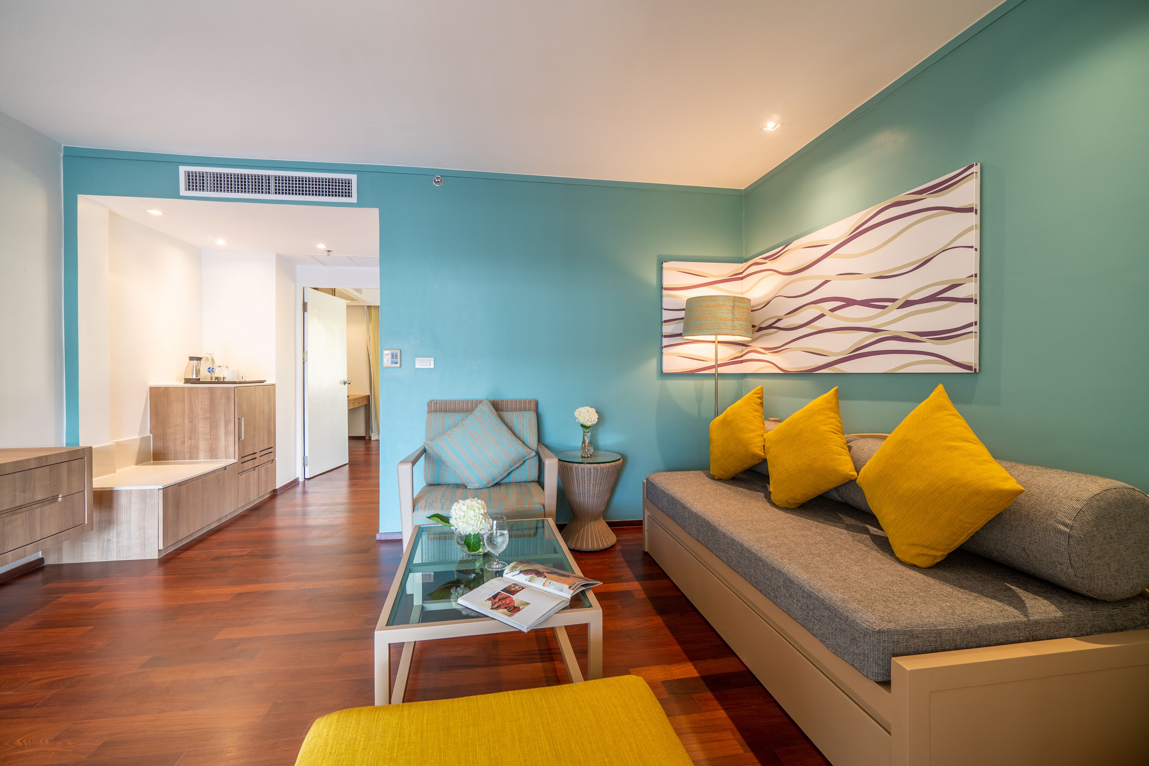 A modern living room with a sofa, coffee table, and a painting on the wall.