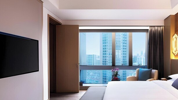 Une chambre d’hôtel moderne dotée d’un grand lit, d’une télévision à écran plat, d’une vue sur la ville et d’une fenêtre avec des rideaux.