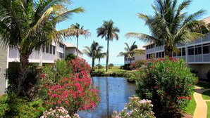 A resort with a water feature, palm trees, and a pathway. - Sanibel Siesta on the Beach (Sanibel)