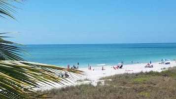 Vlak bij het strand, wit zand, parasols