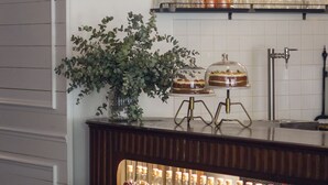 A bar area with a wooden counter, bottles of liquor, and decorative items.