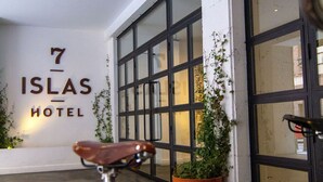A bicycle parked in front of a building with a sign that reads "7 ISLAS HOTEL".