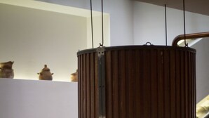 A modern interior with a central fire feature, a hanging light fixture, and a sofa.