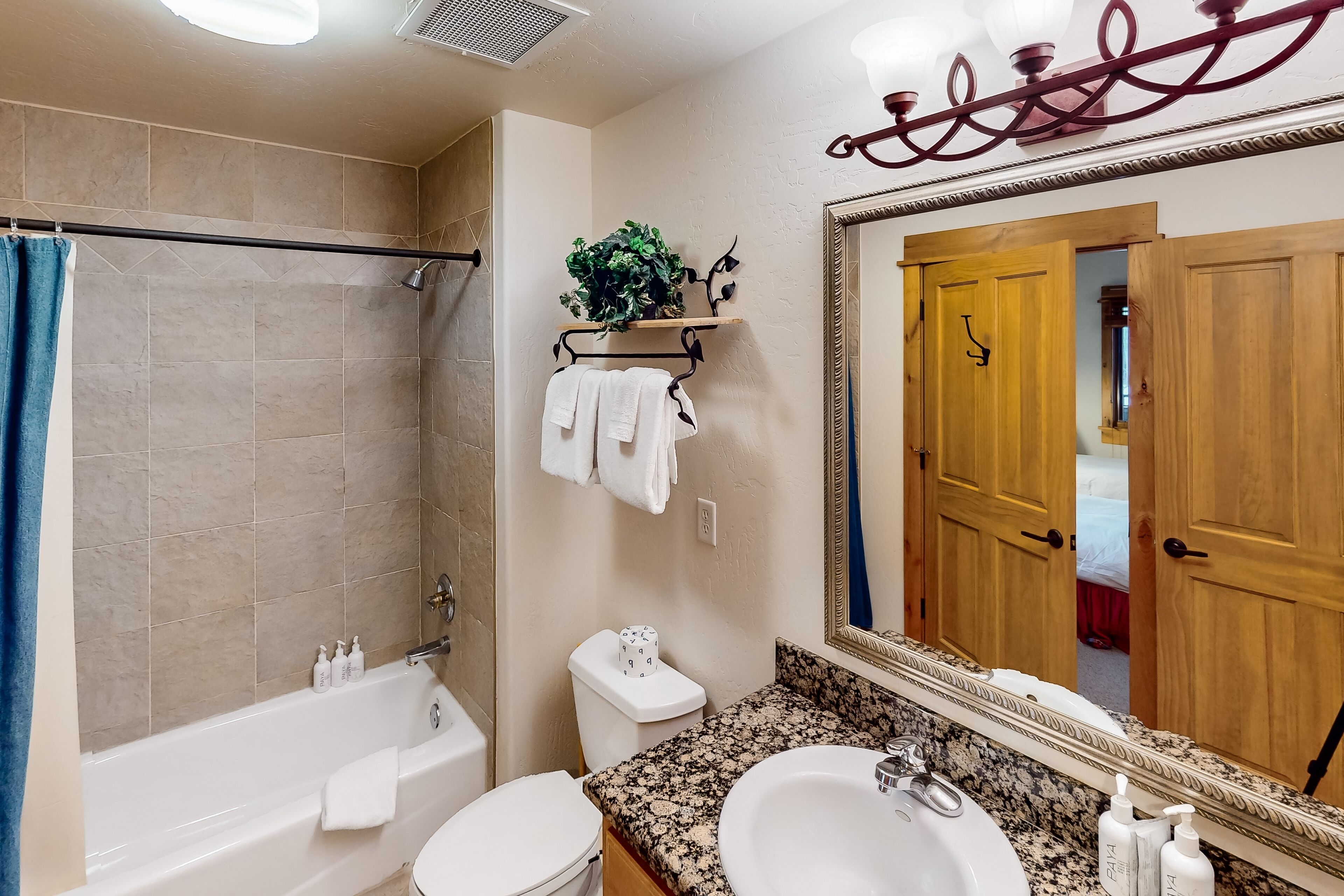 A bathroom with a bathtub, toilet, sink, and a mirror.