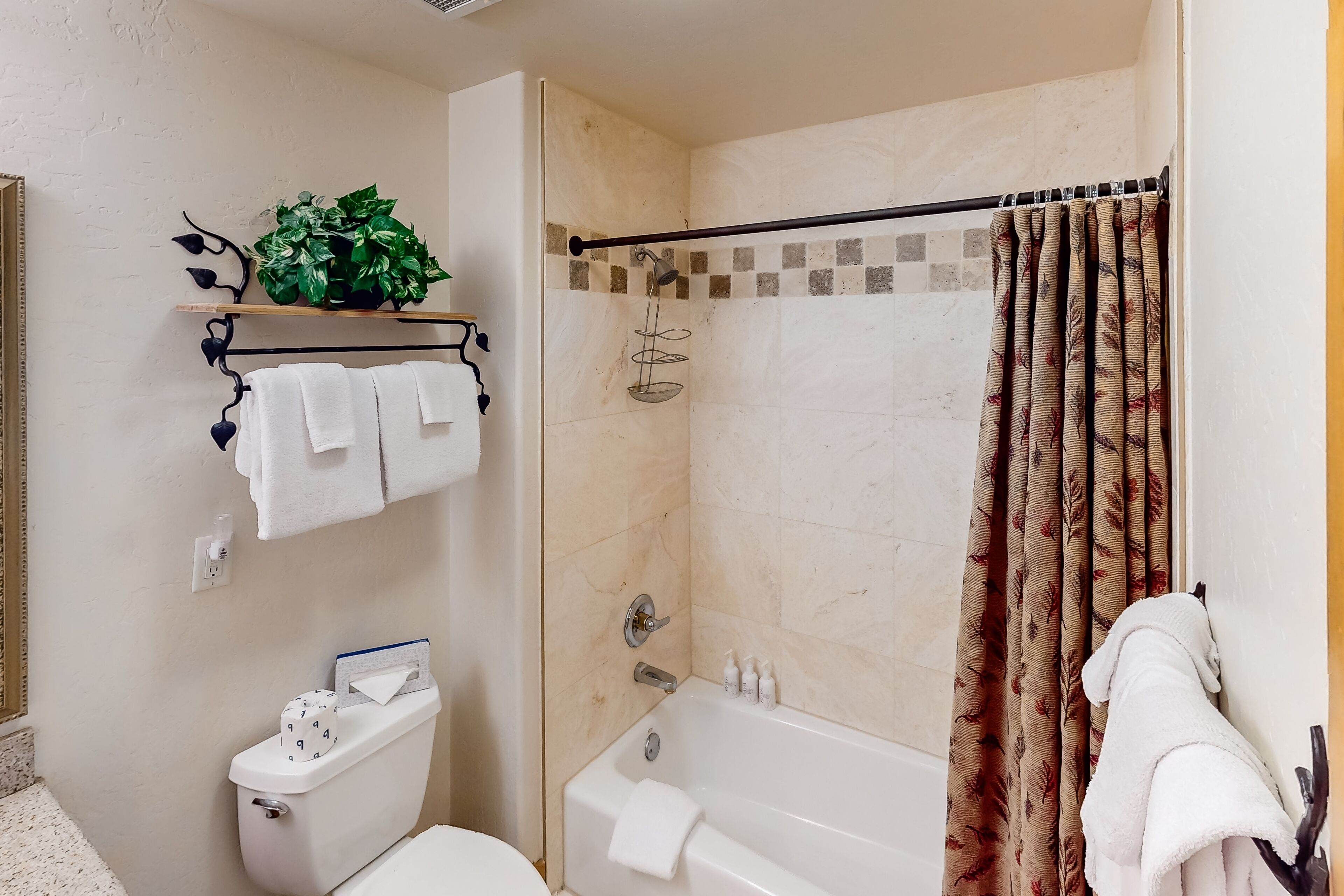 A bathroom with a toilet, a sink, a bathtub, and a shower curtain.
