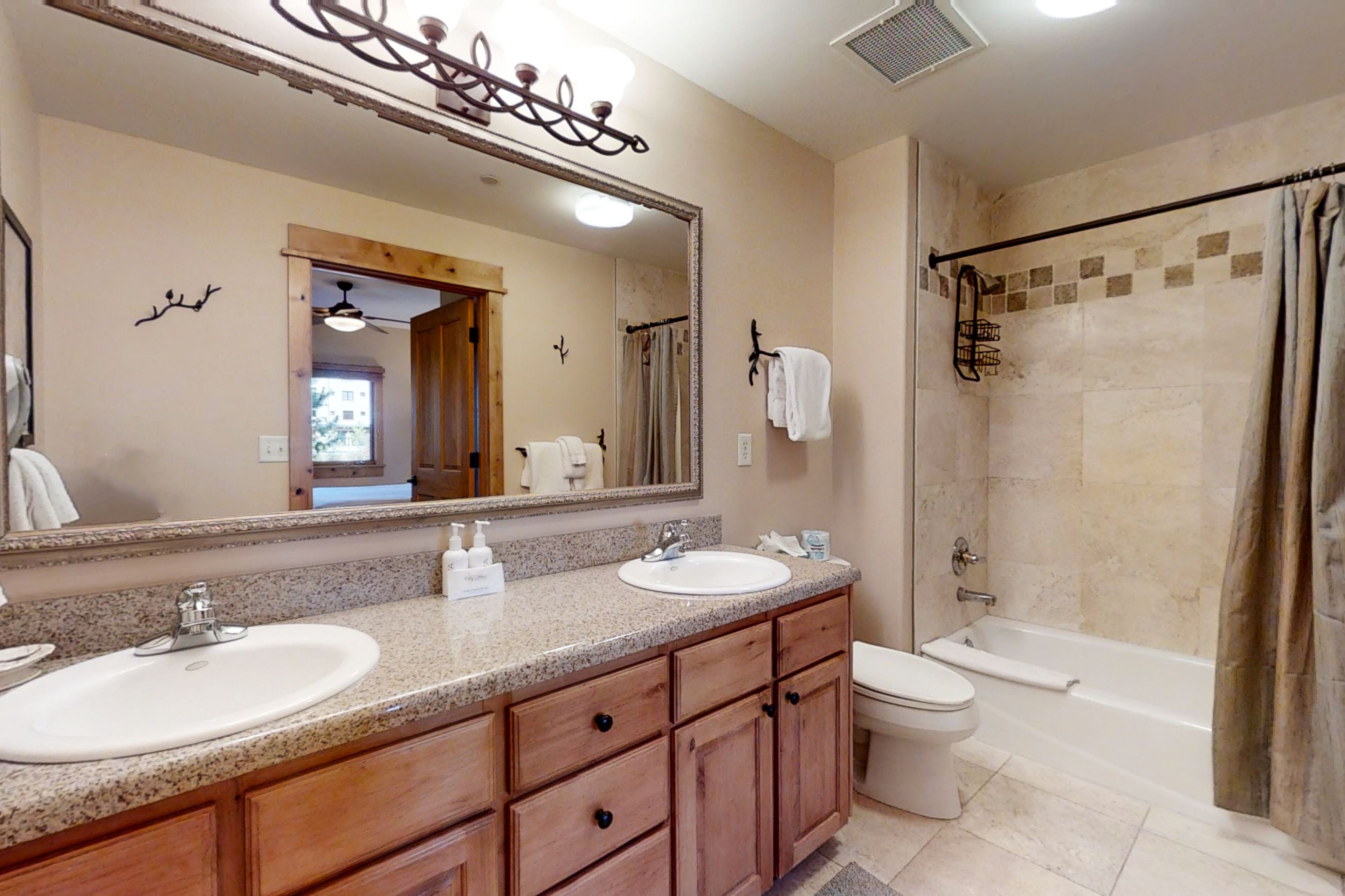 Une salle de bain avec deux lavabos, des toilettes et une baignoire.