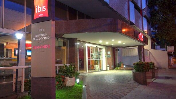 The exterior of the ibis hotel with a prominent sign, a glass entrance, and a well-lit entrance area. - ibis Vitoria Praia Do Canto (Vitoria)