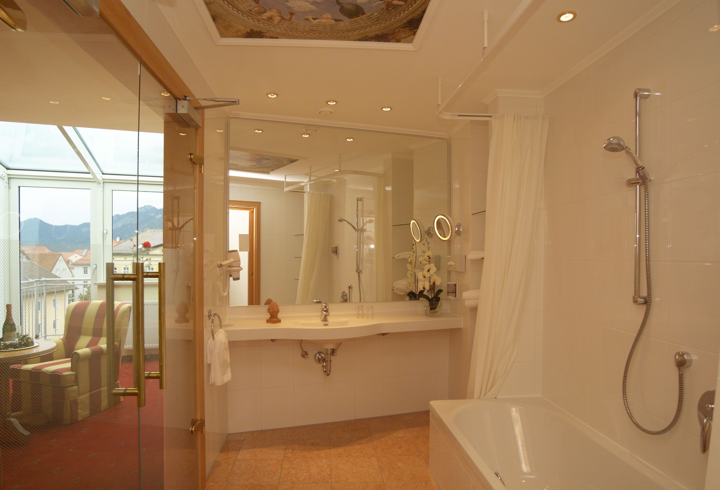 A modern bathroom with a glass shower enclosure, a bathtub, and a vanity with a mirror.
