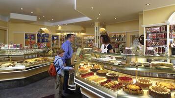 A bakery with a variety of cakes and pastries displayed in glass cases.
