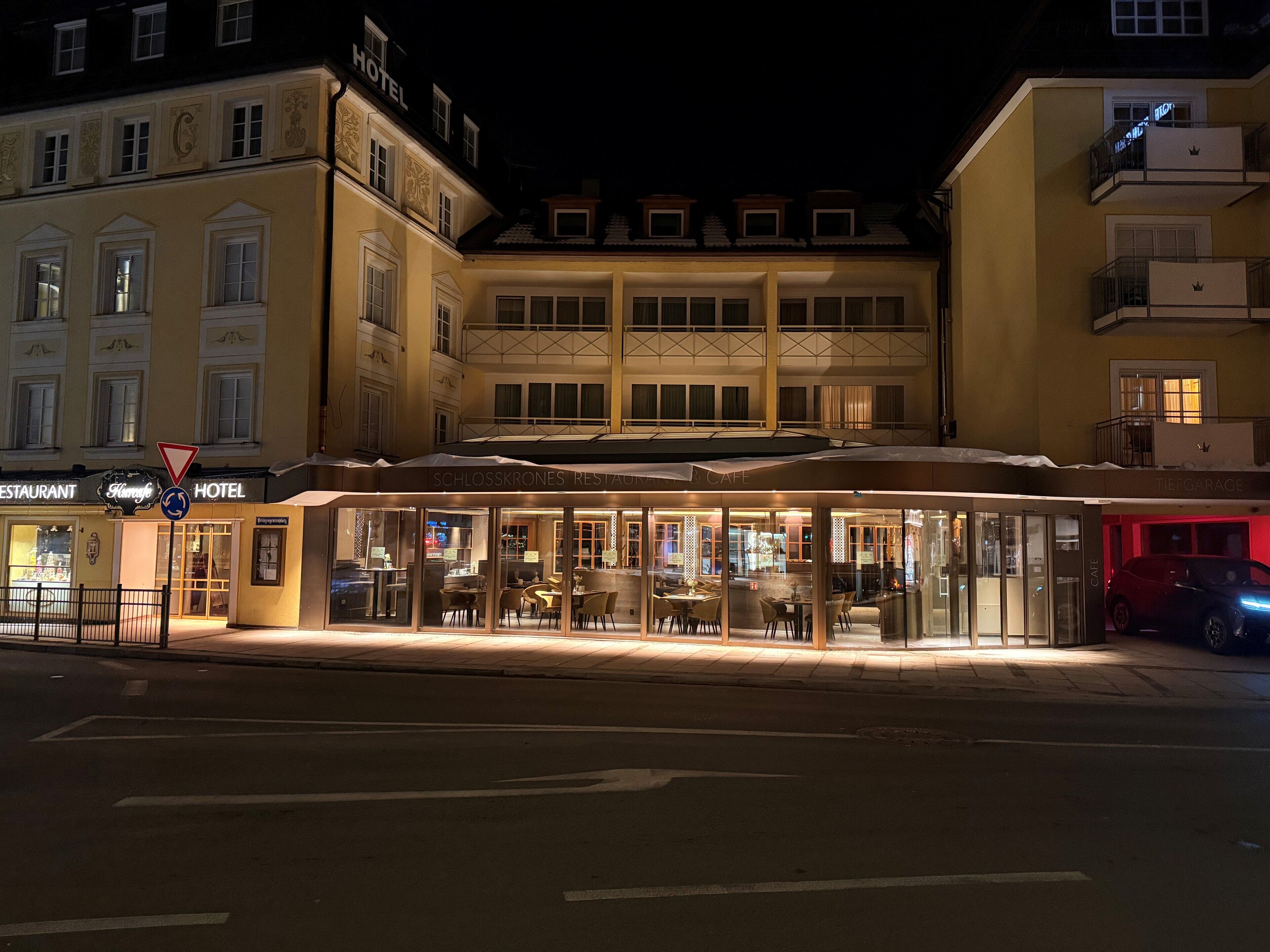 A hotel with a ground-floor restaurant and cafe, a visible entrance, and a street view.
