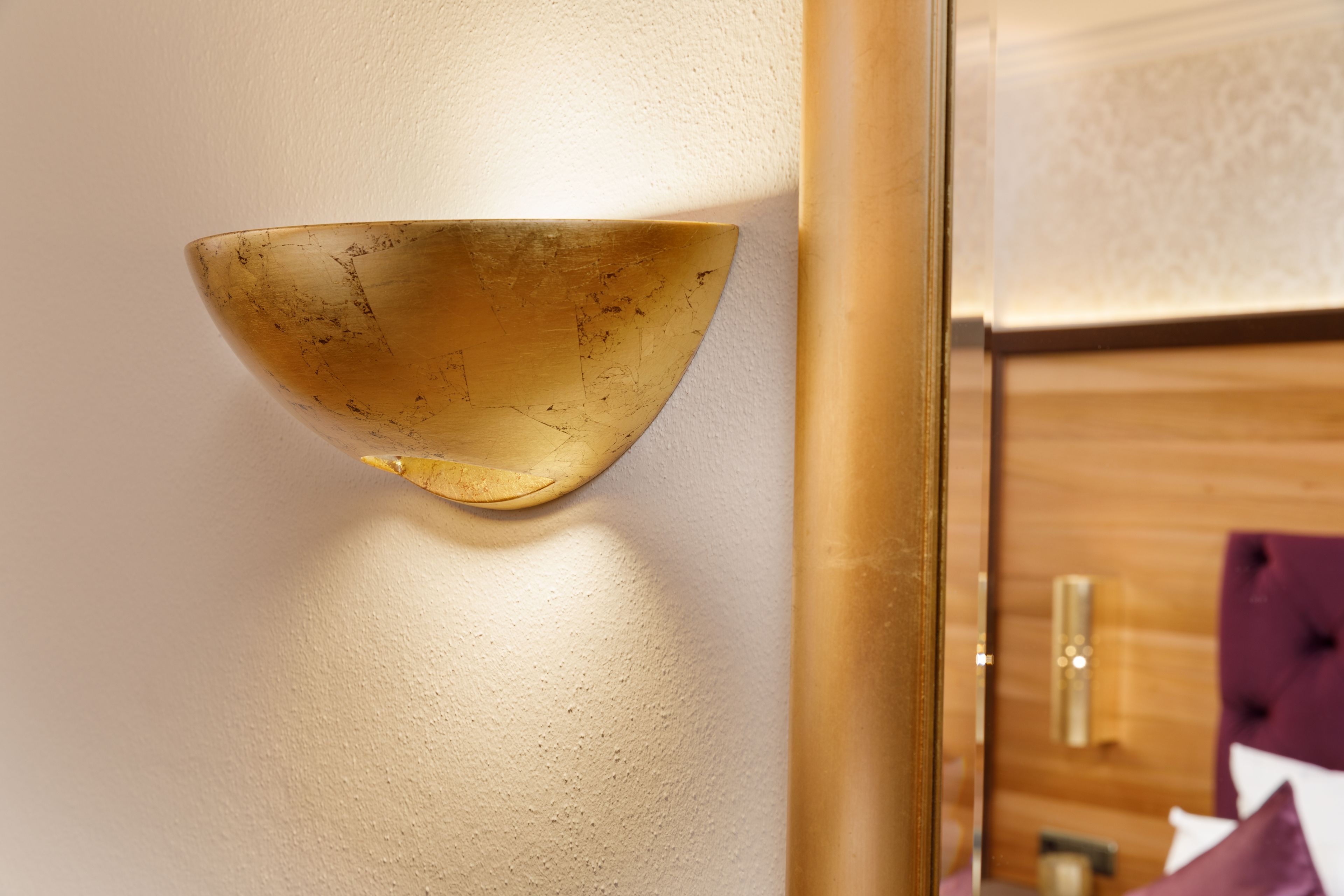 A wall-mounted light fixture with a bowl-shaped design.