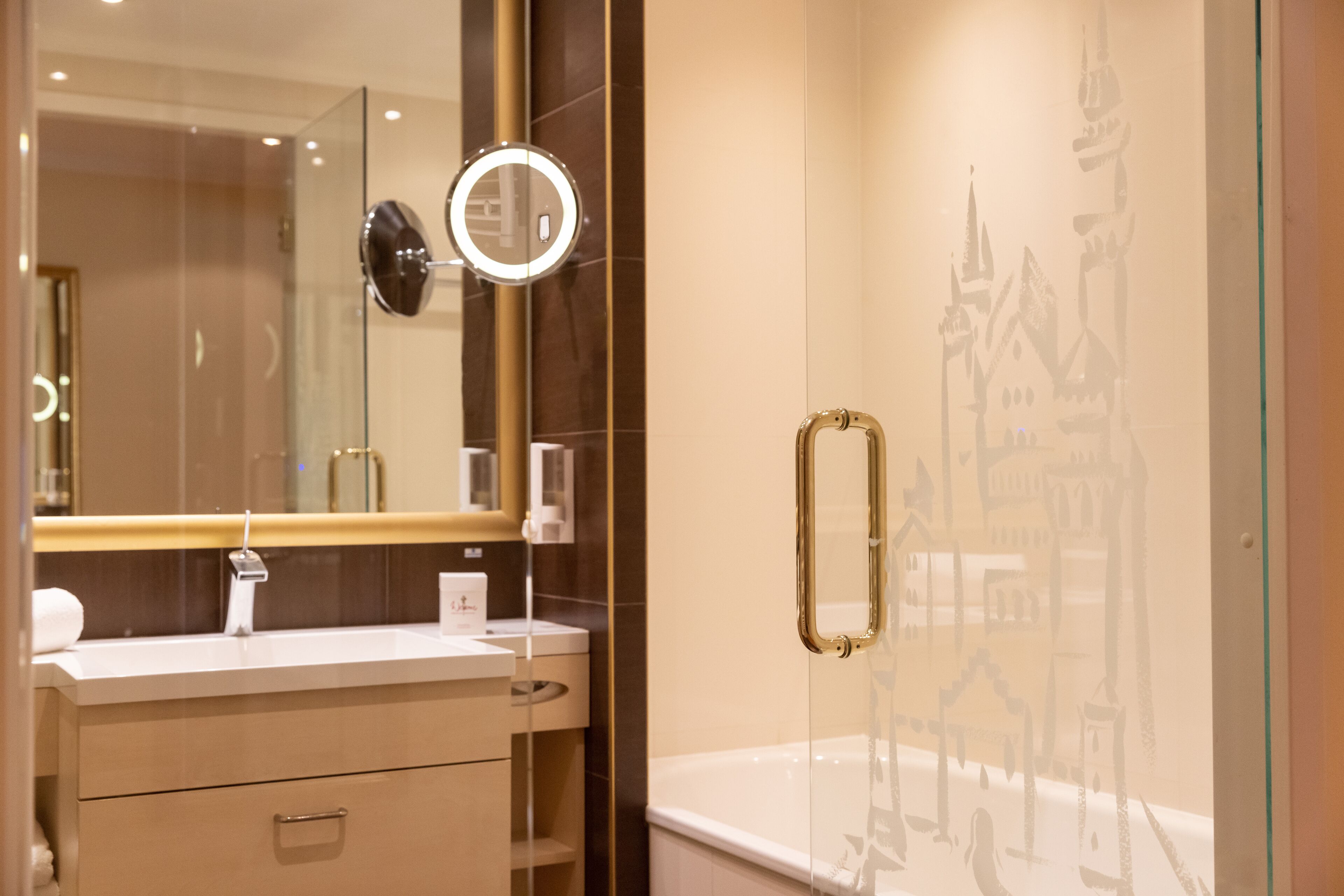 A modern bathroom with a glass shower enclosure, a vanity with a mirror, and a decorative wall.