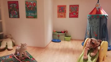 Children can play and explore in this vibrant playroom featuring a play mat, teddy bears, and a toy horse.