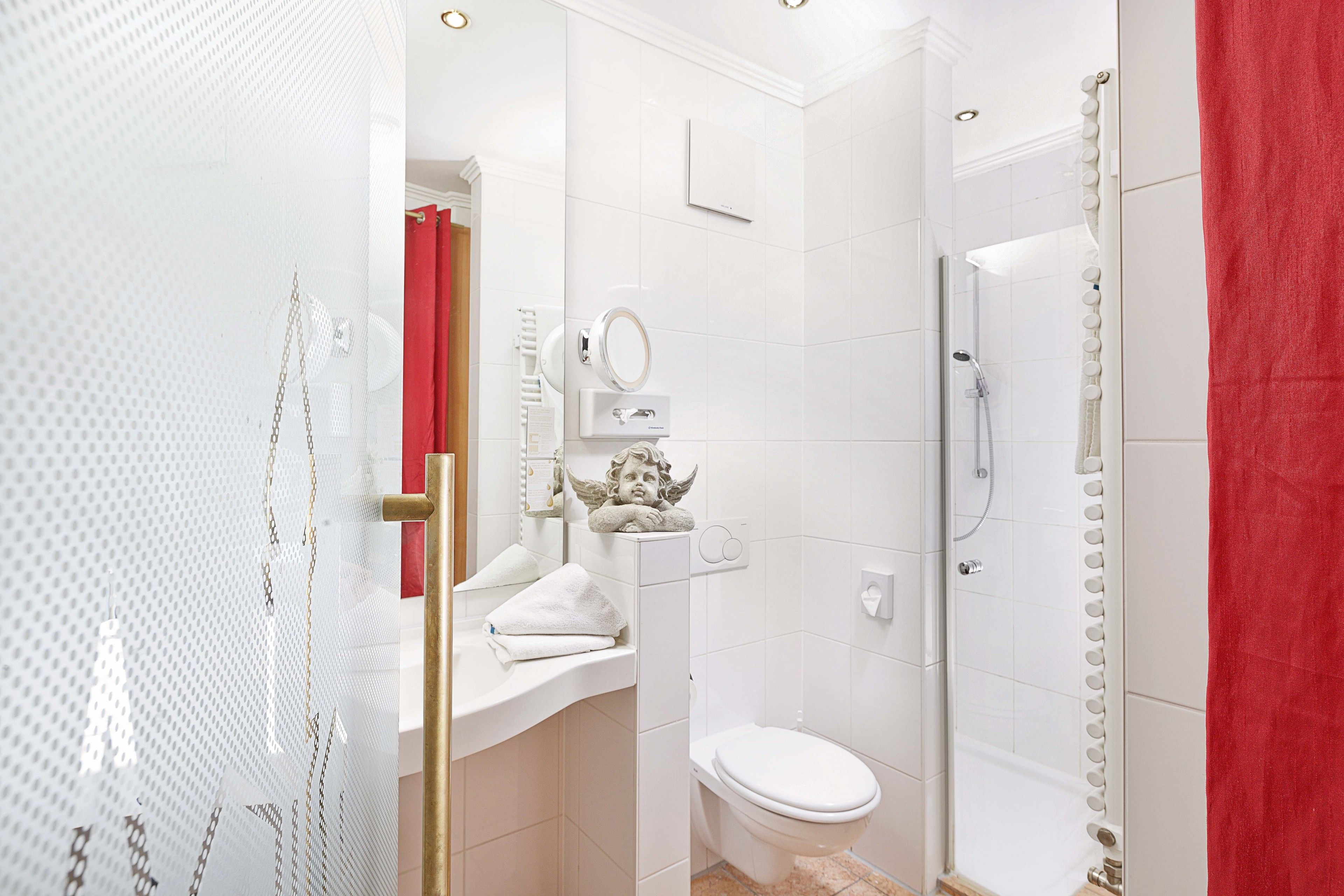 A modern bathroom with a toilet, sink, and shower.
