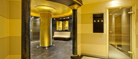 A luxurious lobby with marble flooring, gold accents, and a reception desk.