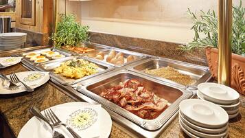 Un bufé con diversas opciones de comida, incluyendo huevos, tocino y huevos revueltos.