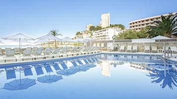 Een seizoensgebonden buitenzwembad, ligstoelen bij het zwembad